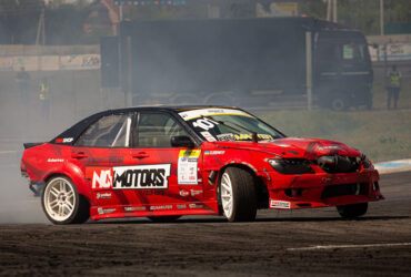 Красный гоночный автомобиль в дыму