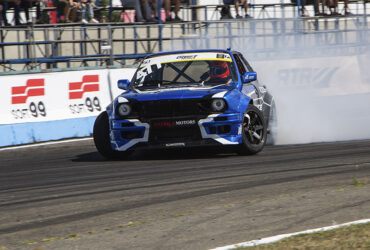 Синяя гоночная машина на автодроме