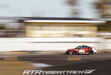 красный гоночный автомобиль на трасе тайматак