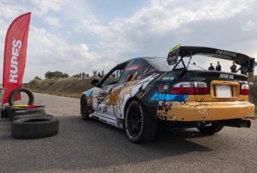 флаг Rupes и гоночное авто на трассе