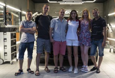 студенты школы детейлинга возле готового автомобиля