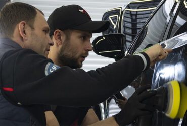 инструктор объясняет студенту как полировать кузов