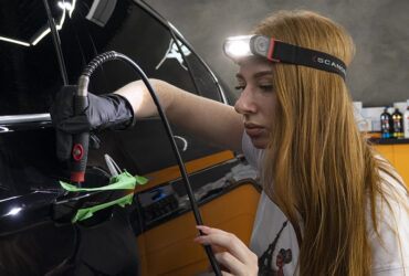 студентка полирует участки под дверными ручками авто