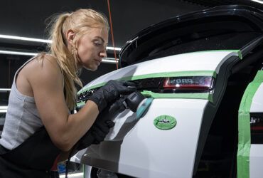 студентка Ирина полирует кузов